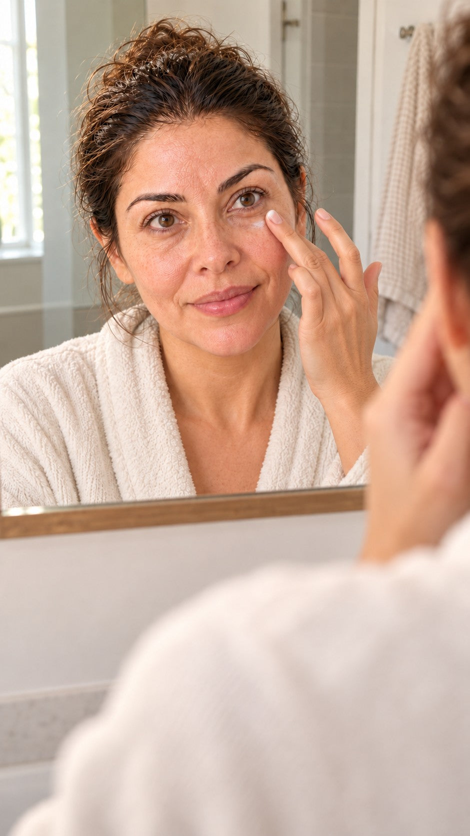 Mujer aplicándose crema en el contorno de ojos